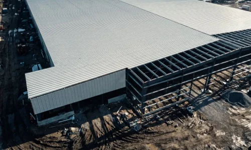 Large scale industrial workshop utilizing trapezoidal metal roof sheets for practical and efficient roof area coverage